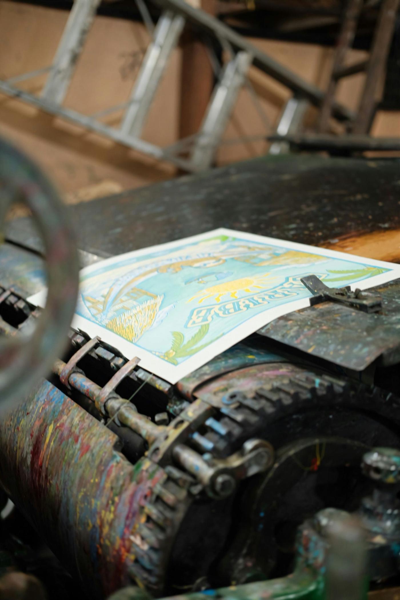 A printed sheet emerging from a multi-colour litho press